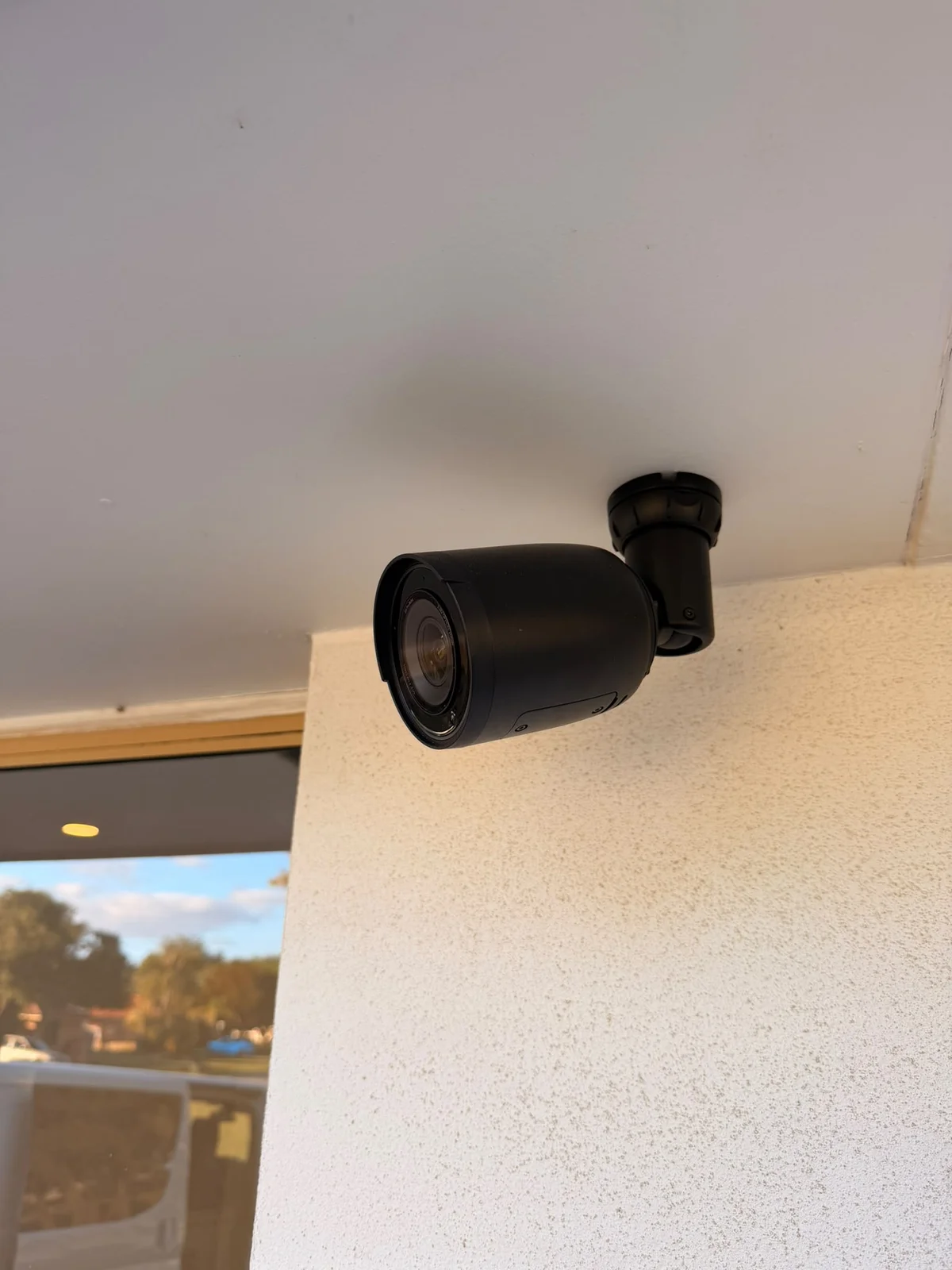 Bullet security camera mounted beneath the eaves at the Waikiki home